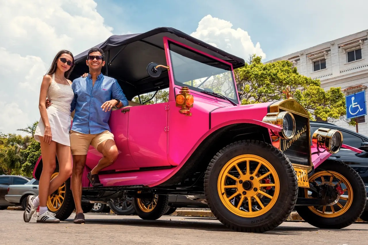 Couple next to a pink vintage car