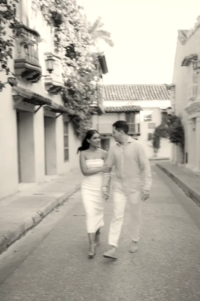Couple walking down a cobbled street, in black and white