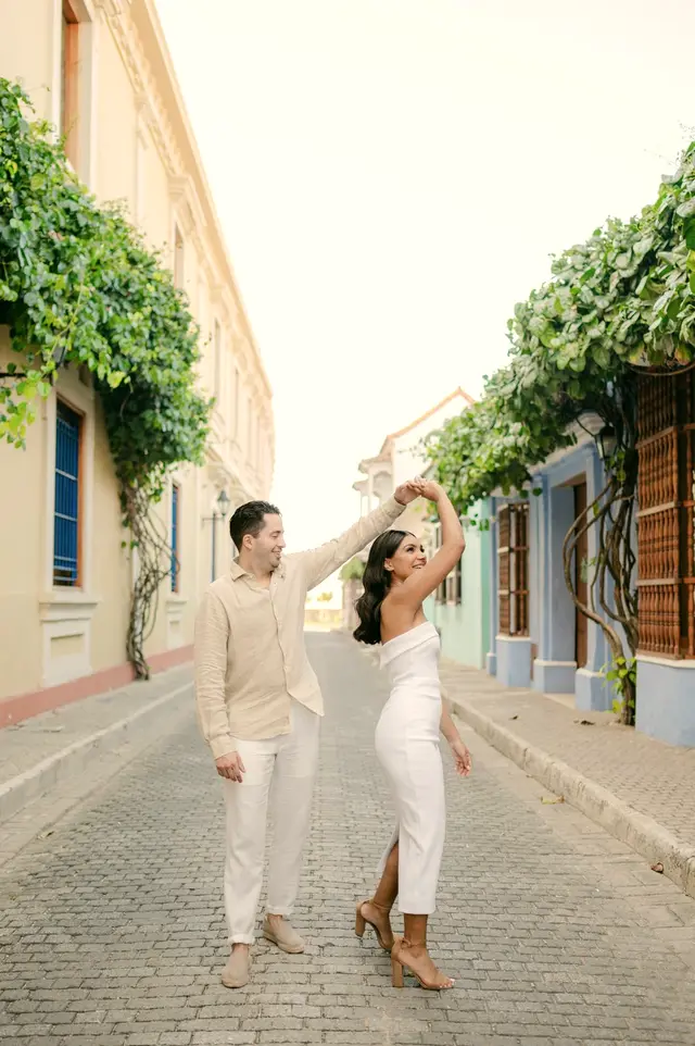 Couple dancing on a cobbled street between colonial houses