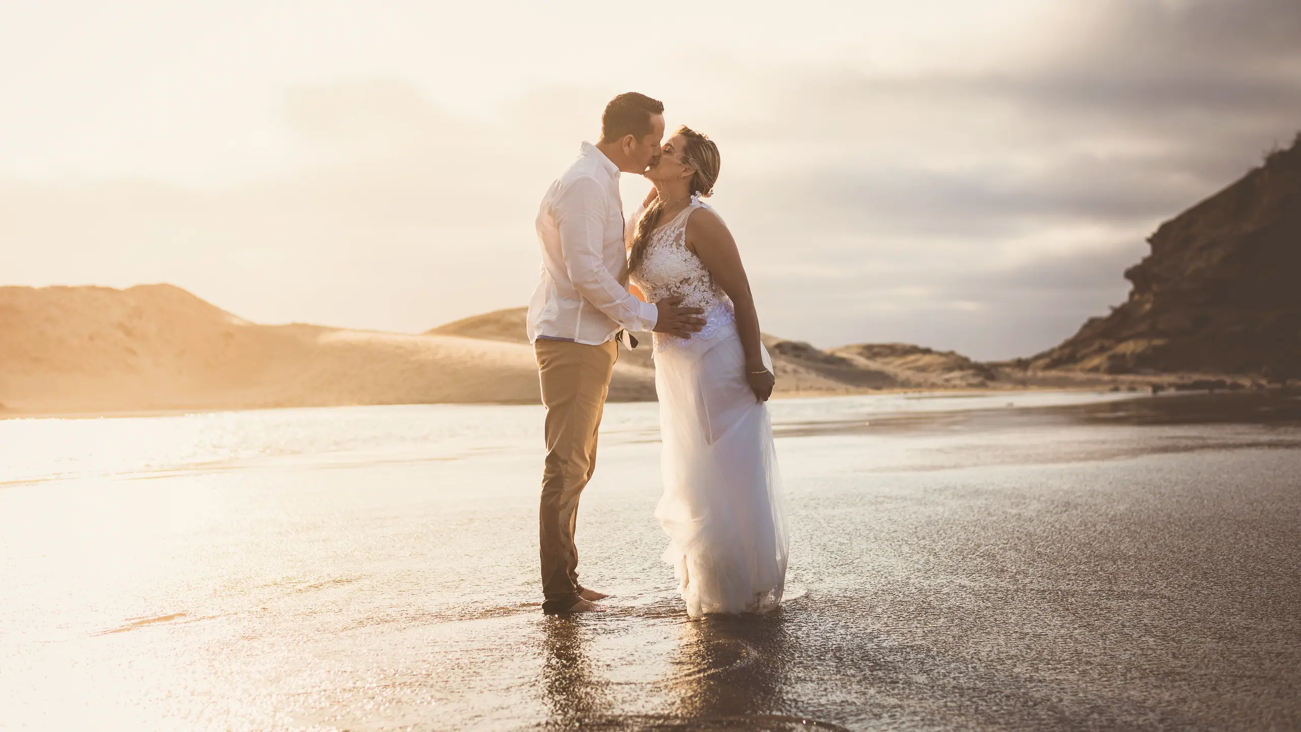 Couple kissing on an open beach in soft light