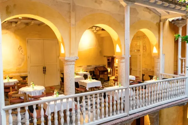 Dining room under colonial arcades with set tables and a tiled floor
