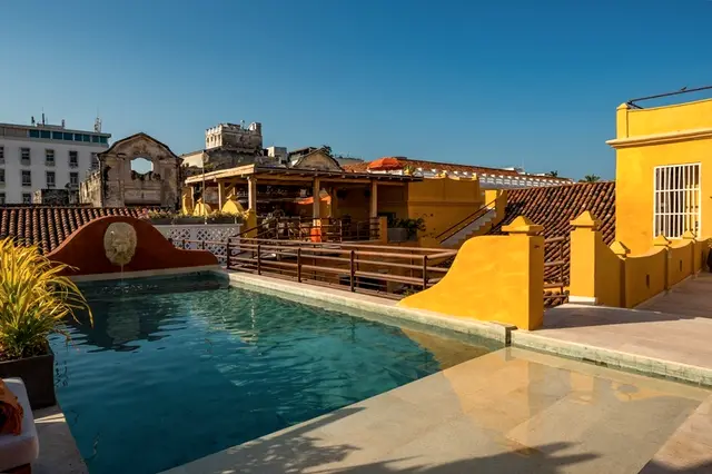 Rooftop pool between yellow walls and the roofs of the walled city