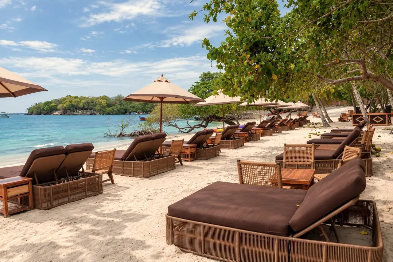 Island beach with wooden loungers and umbrellas facing the sea