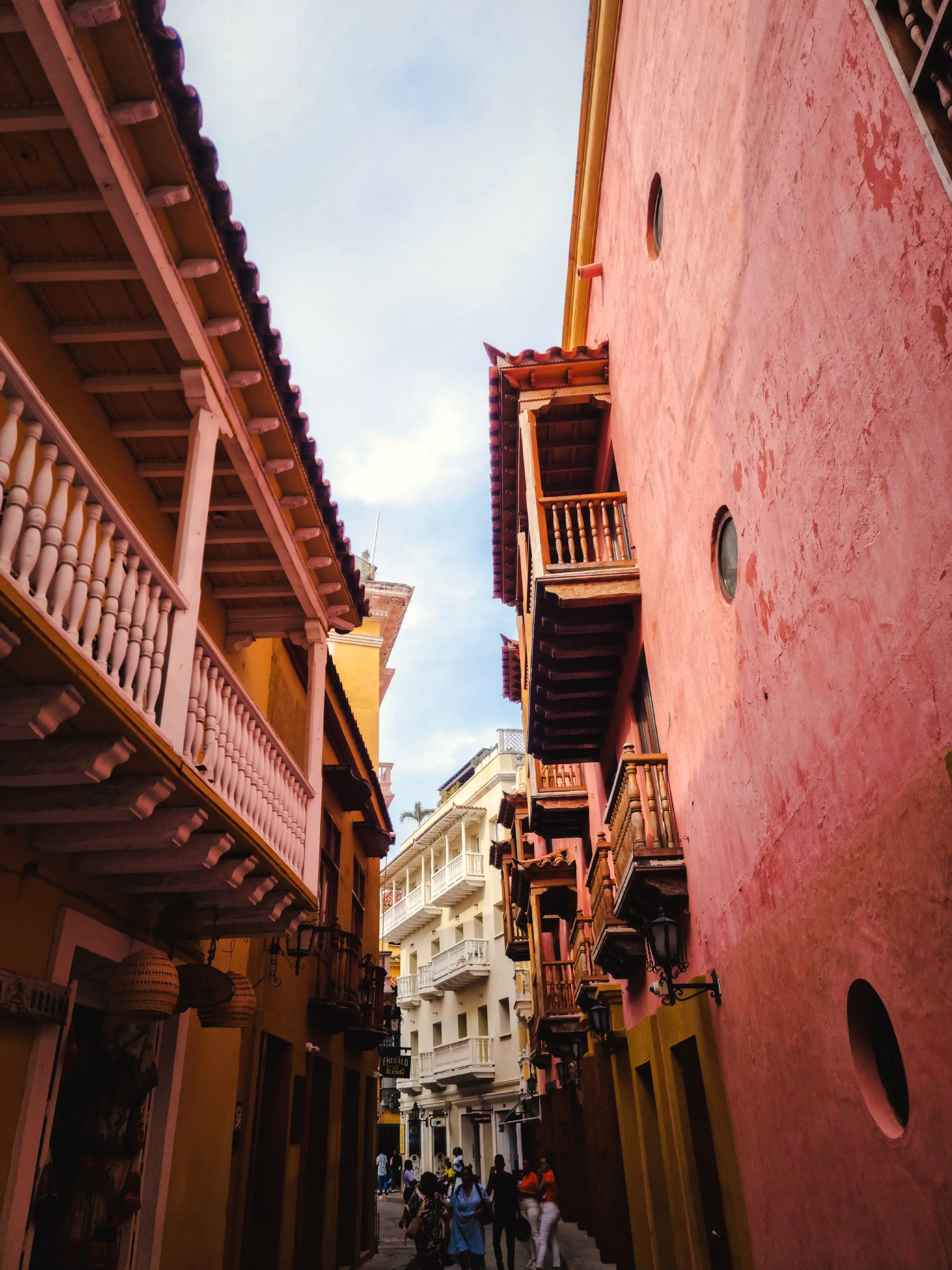 Narrow alley in the historic center between pink walls and wooden balconies