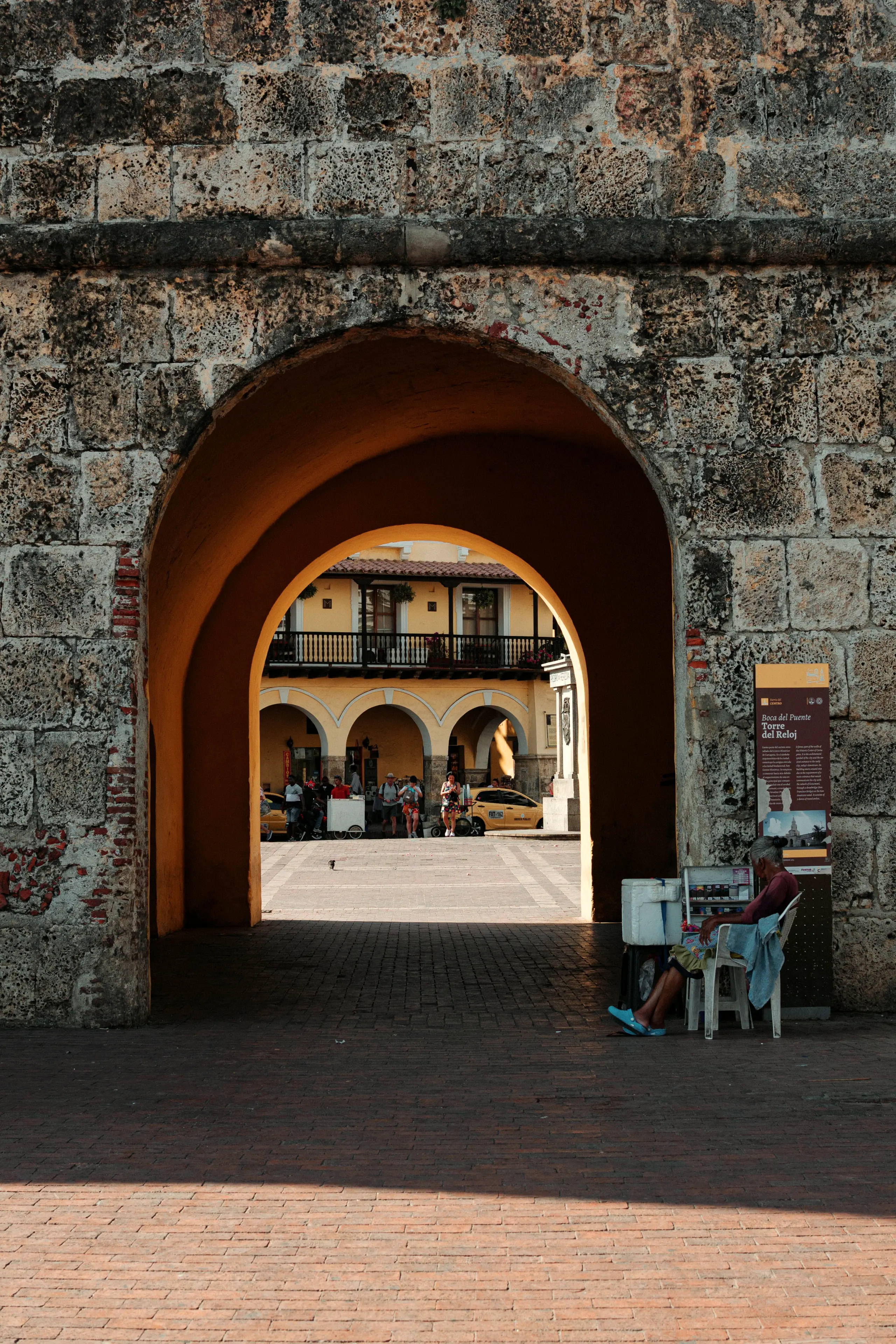 Stone arch in the city wall with the plaza beyond