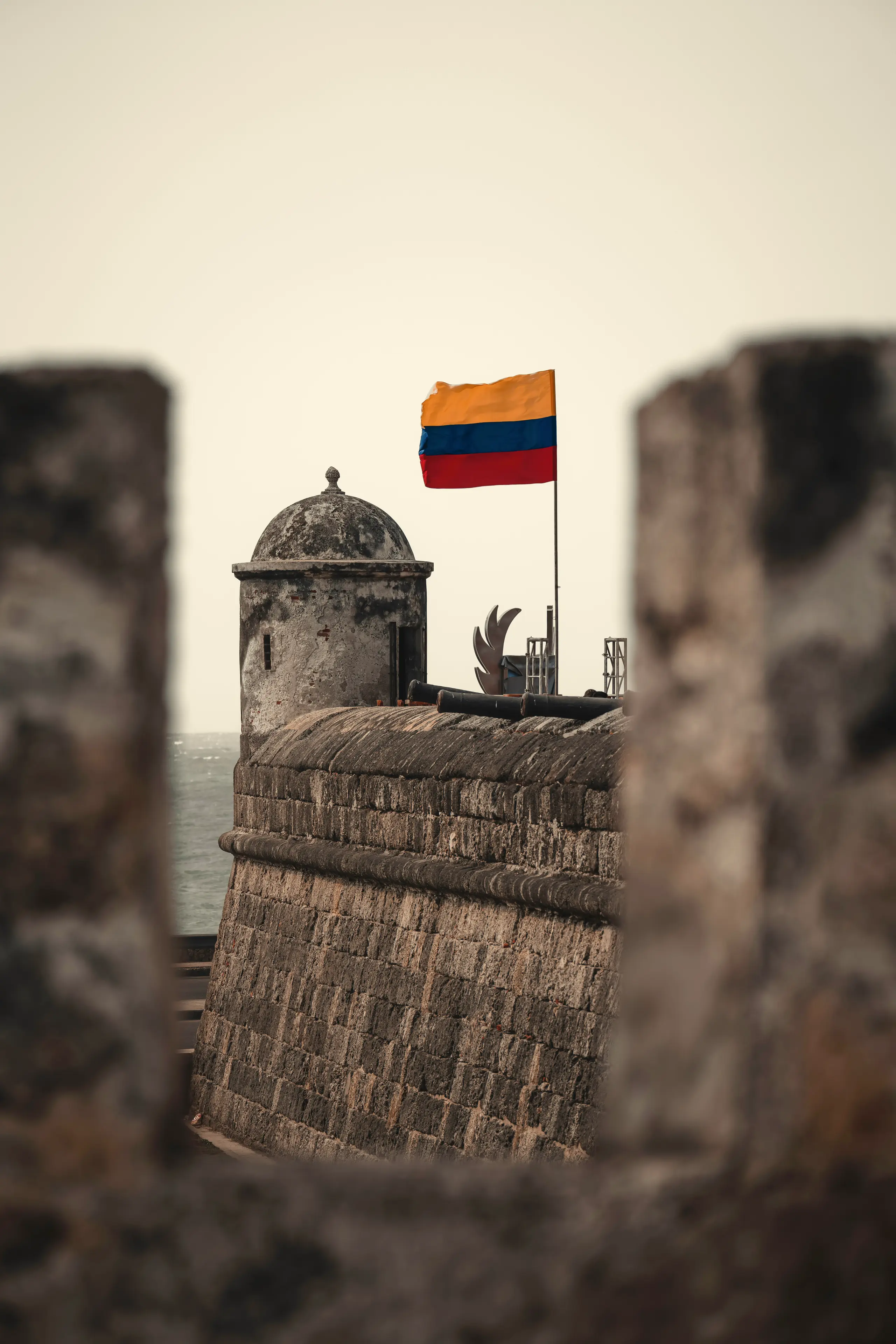 Wall watchtower flying the Colombian flag between two stone blocks