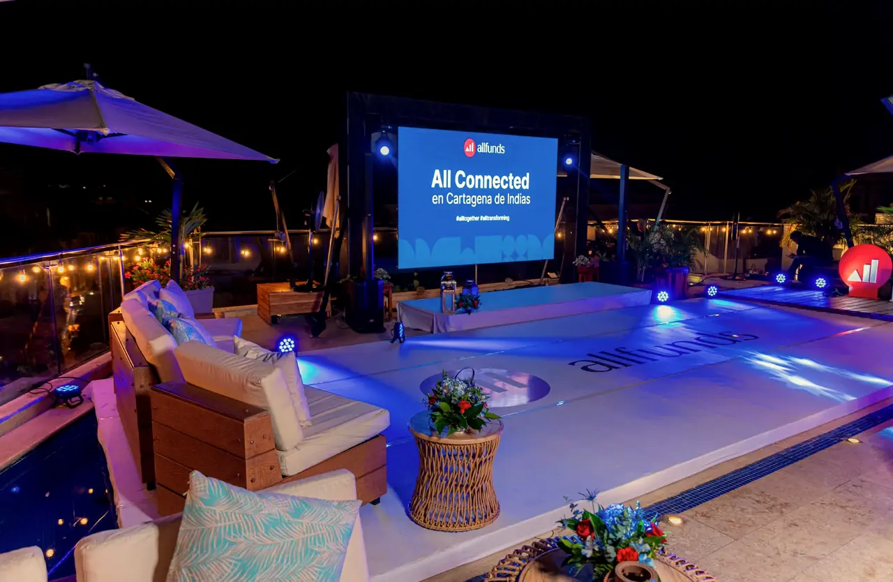 Terrace at night with a screen, sofas and a lit pool for a corporate event