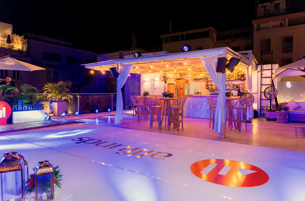 Lit bar and pergola on a terrace at night during a corporate event