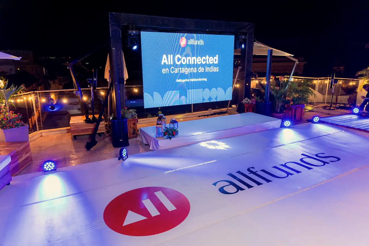 Lit screen and stage on the terrace at a corporate night event