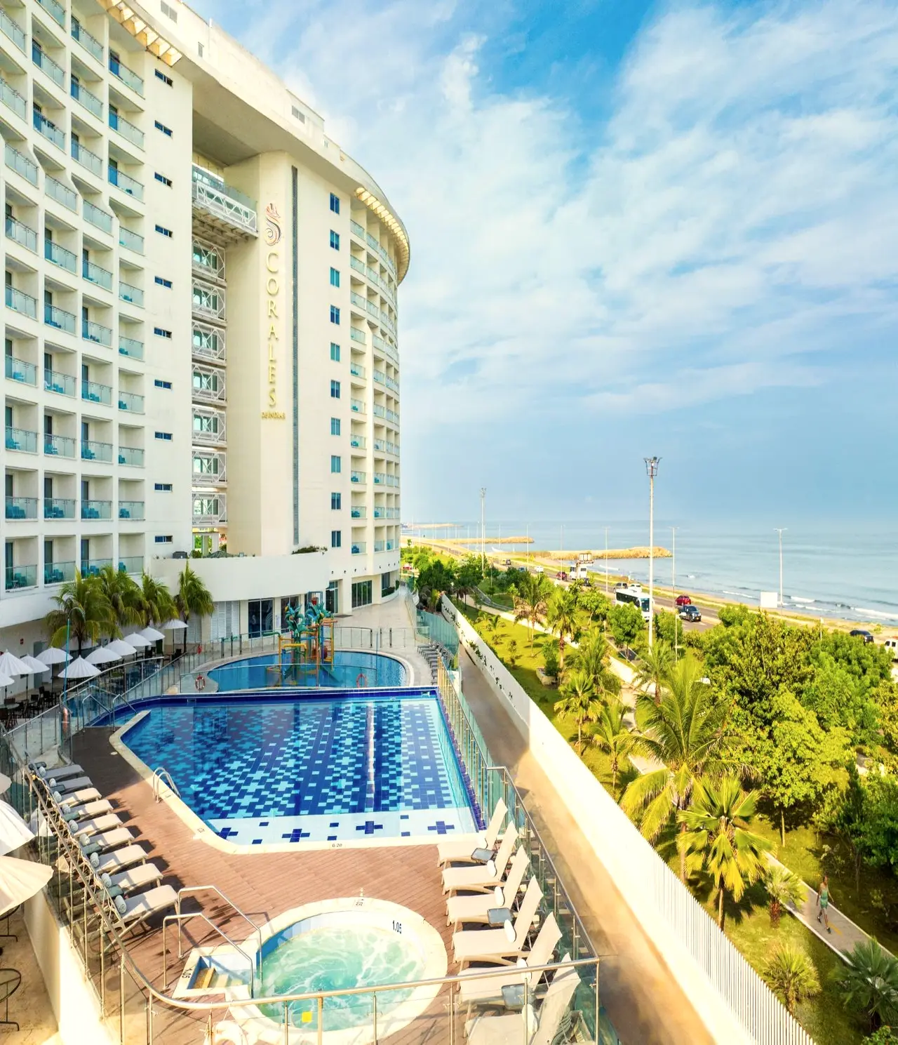 Torre del hotel con piscina y jardines frente al mar