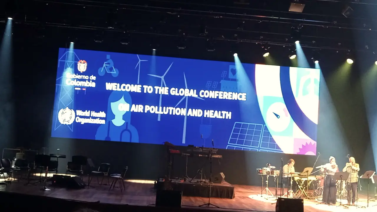 Theater stage with a large screen welcoming an international conference