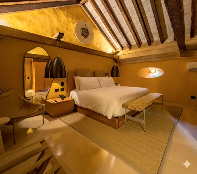 Habitación con vigas de madera, cama blanca y luz cálida