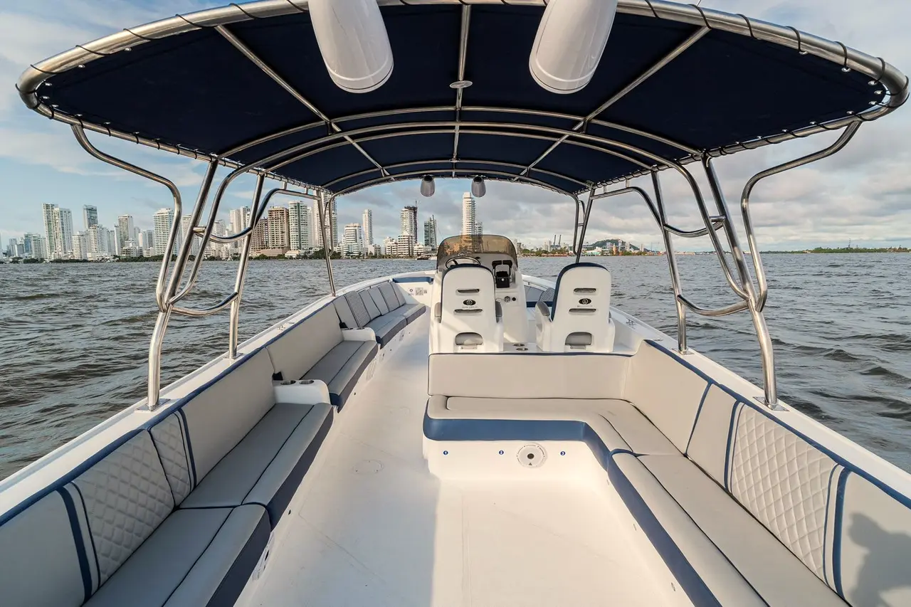 Boat deck under a blue canopy with a high-rise skyline beyond