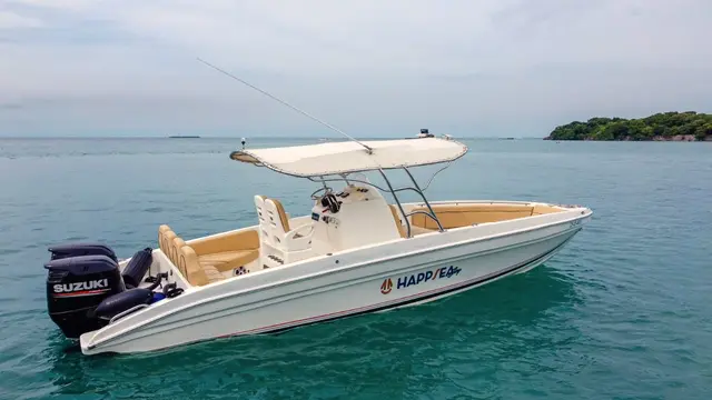 White boat with a light canopy anchored off an island