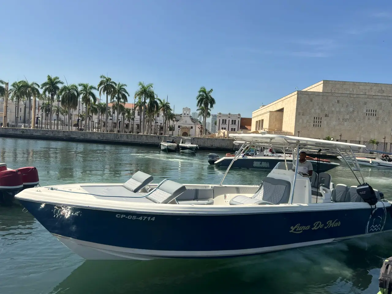 Blue boat moored at a marina in front of a stone building