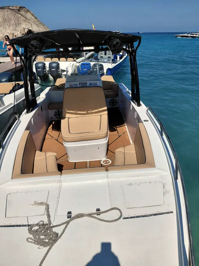 Bow of a boat with a dark canopy on turquoise water