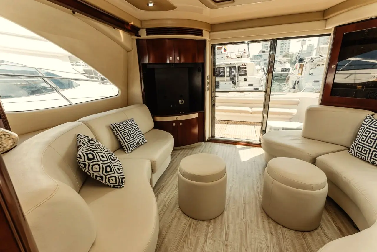 Yacht salon with cream sofas and windows toward the marina