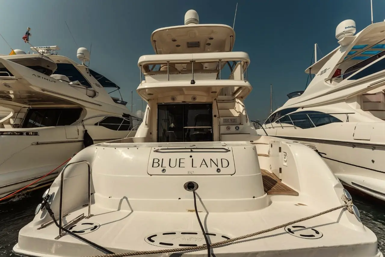 Stern of a white yacht in a marina among other yachts